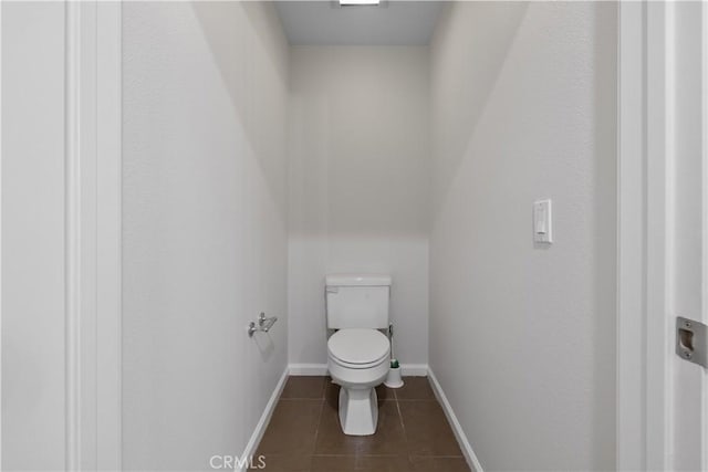 bathroom featuring tile patterned flooring, toilet, and baseboards