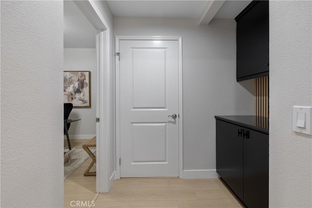 hall with light wood finished floors and baseboards