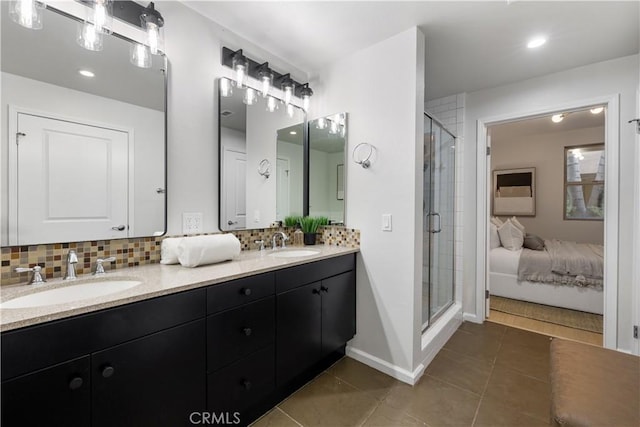 bathroom with a stall shower, a sink, decorative backsplash, and tile patterned floors