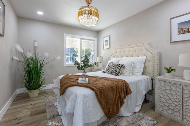 bedroom featuring recessed lighting, a notable chandelier, baseboards, and wood finished floors