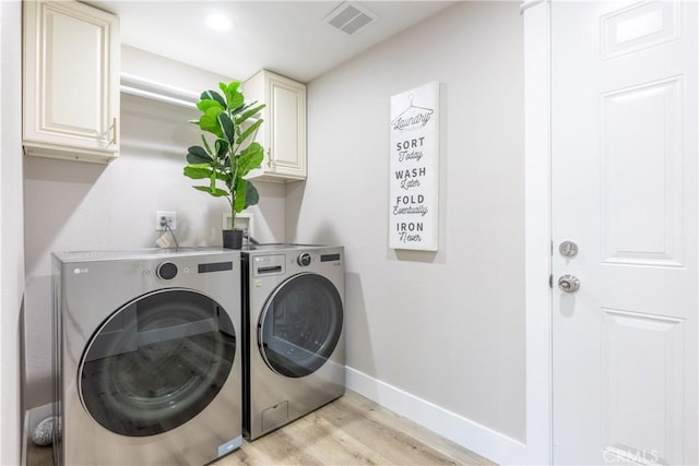 laundry area with cabinet space, visible vents, light wood-style flooring, independent washer and dryer, and baseboards