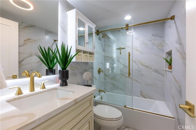 full bathroom featuring toilet, tile walls, vanity, combined bath / shower with glass door, and decorative backsplash