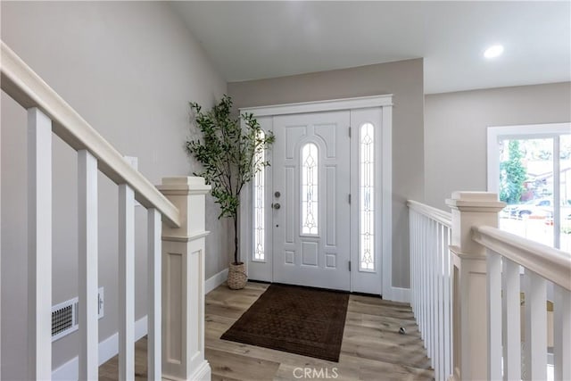 entrance foyer featuring light wood finished floors, stairs, visible vents, and recessed lighting