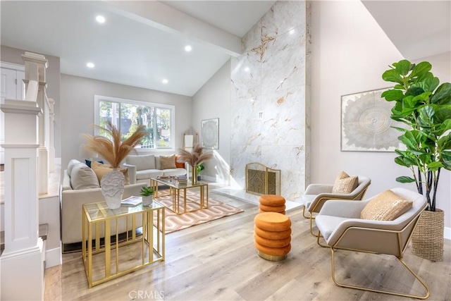 living area featuring recessed lighting, decorative columns, beam ceiling, and wood finished floors