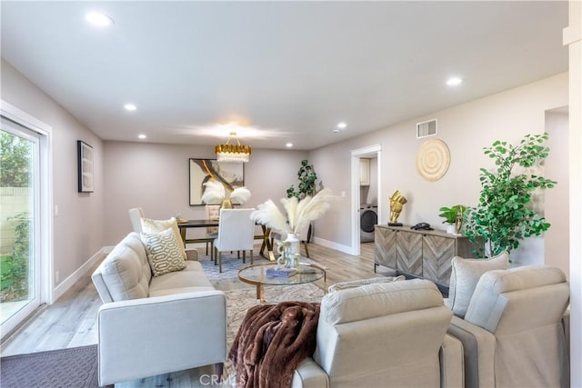 living room featuring light wood finished floors, washer / dryer, baseboards, visible vents, and recessed lighting