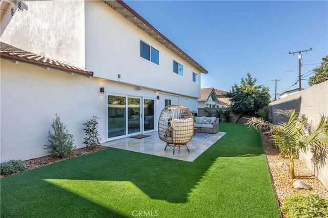 back of property featuring a fenced backyard, a patio, a lawn, and stucco siding