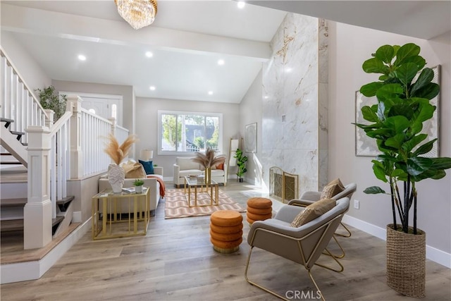 sitting room with wood finished floors, a fireplace, baseboards, and stairs