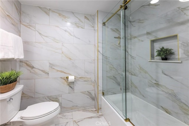 bathroom featuring toilet, marble finish floor, and enclosed tub / shower combo