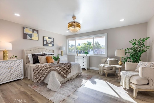 bedroom with a chandelier, recessed lighting, baseboards, and wood finished floors