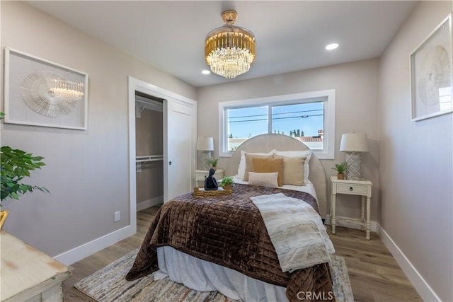 bedroom featuring recessed lighting, an inviting chandelier, wood finished floors, and baseboards