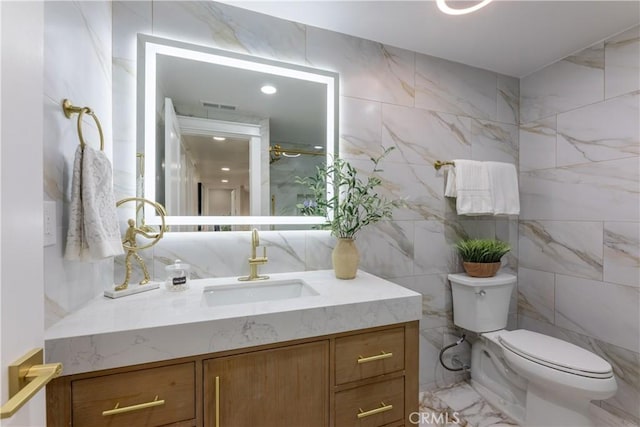 bathroom with marble finish floor, visible vents, vanity, and toilet