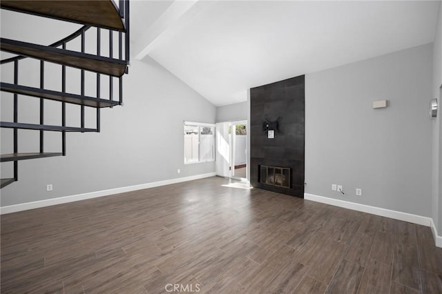 unfurnished living room with a large fireplace, beam ceiling, baseboards, and dark wood-style flooring