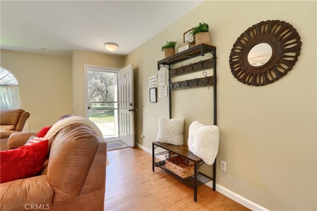 doorway to outside with light wood finished floors and baseboards