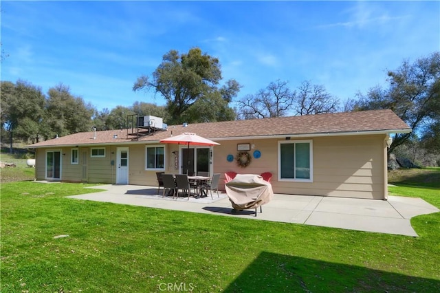 rear view of house with a lawn and a patio