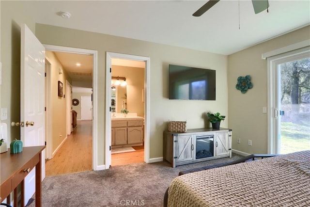 carpeted bedroom featuring access to exterior, a ceiling fan, baseboards, and connected bathroom