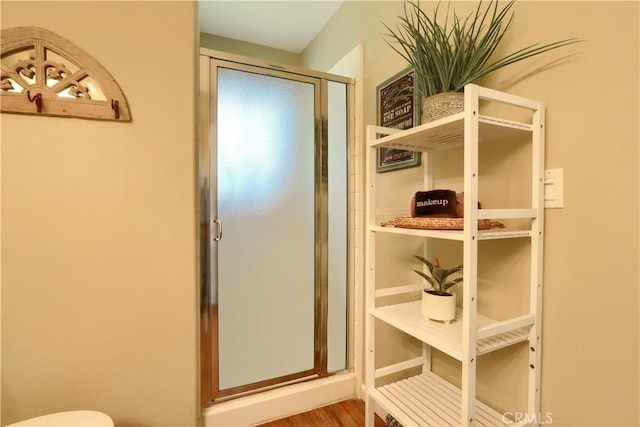 bathroom featuring a stall shower and toilet