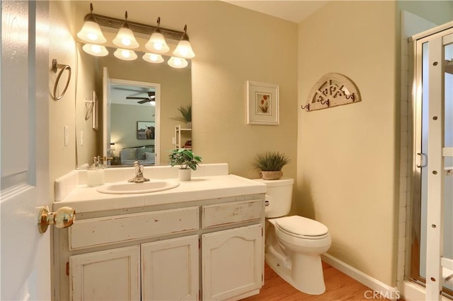 ensuite bathroom with a shower with door, toilet, vanity, ensuite bath, and wood finished floors