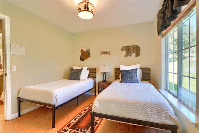 bedroom with light wood finished floors and baseboards