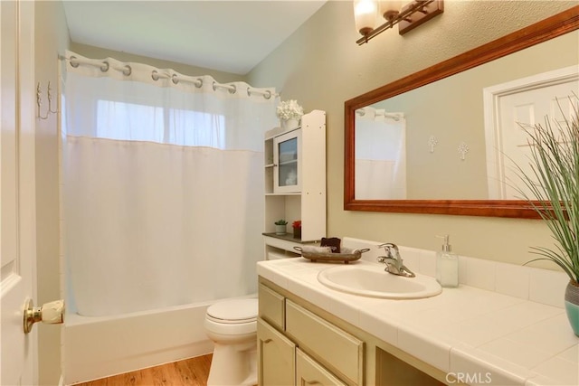 bathroom with wood finished floors, shower / bath combo, vanity, and toilet