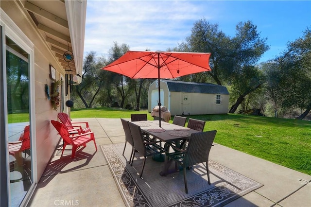 view of patio featuring outdoor dining space, an outbuilding, and a shed