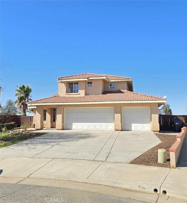 view of front of house with fence, a tiled roof, concrete driveway, stucco siding, and an attached garage