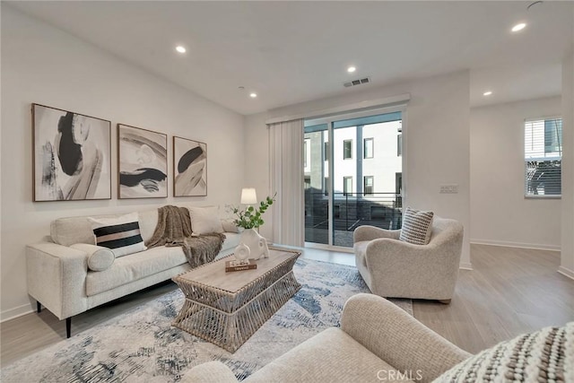 living room featuring wood finished floors, visible vents, and baseboards