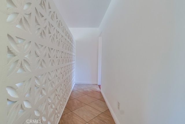 hallway with light tile patterned floors and baseboards