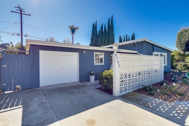 view of front facade with fence and stucco siding