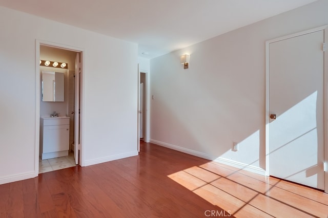 spare room featuring baseboards and wood finished floors