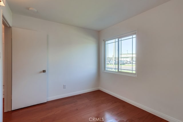 empty room with wood finished floors and baseboards