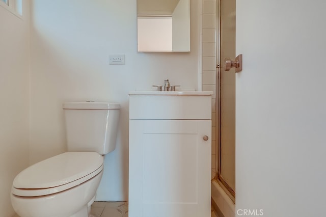 bathroom featuring vanity, a shower with door, and toilet