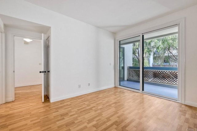 spare room with light wood-type flooring and baseboards