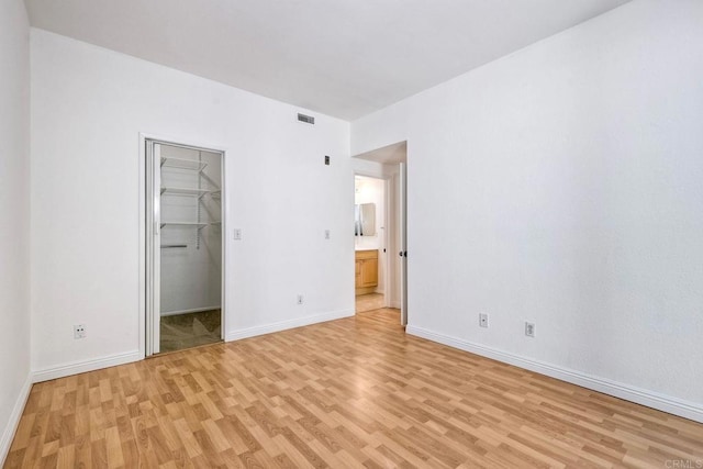 unfurnished bedroom with light wood finished floors, visible vents, and baseboards