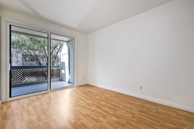 spare room with light wood-style floors and baseboards