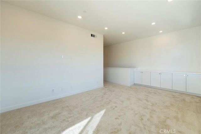 spare room featuring baseboards, recessed lighting, and light colored carpet