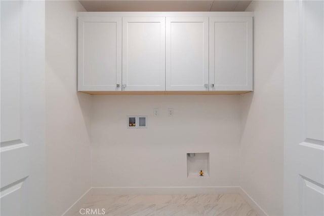 clothes washing area featuring washer hookup, cabinet space, gas dryer hookup, and baseboards