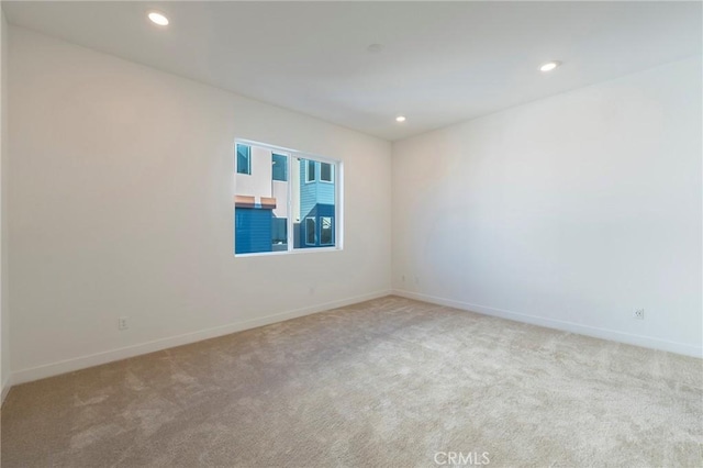 carpeted empty room featuring baseboards and recessed lighting