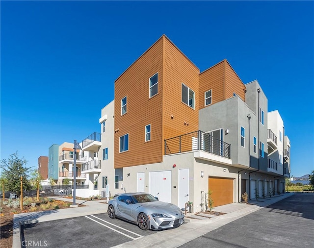 view of property featuring uncovered parking and a garage