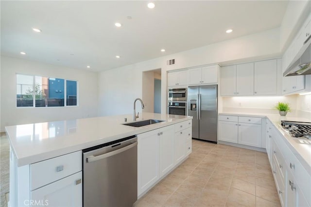 kitchen with recessed lighting, a sink, visible vents, appliances with stainless steel finishes, and a center island with sink