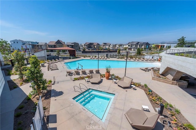 pool featuring a residential view, fence, a community hot tub, and a patio