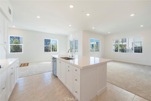 kitchen with light carpet, dishwasher, open floor plan, a sink, and recessed lighting