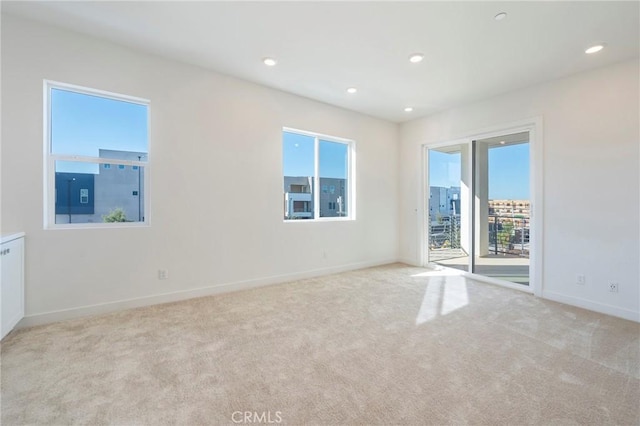 carpeted spare room featuring baseboards and recessed lighting