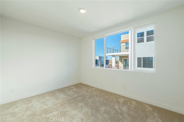 carpeted empty room with baseboards