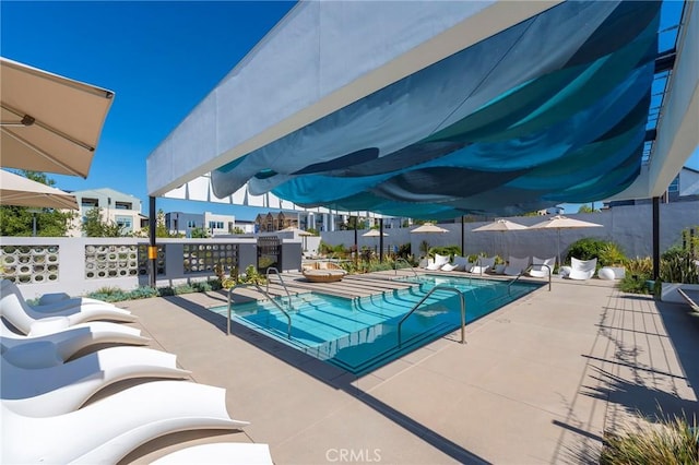 view of swimming pool featuring fence, a fenced in pool, and a patio