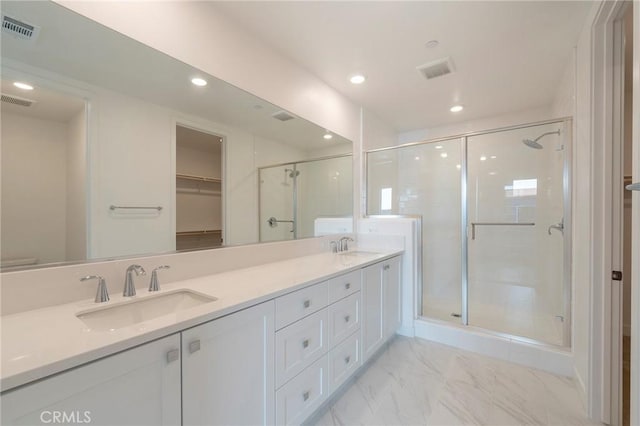 full bathroom featuring double vanity, a stall shower, visible vents, marble finish floor, and a sink