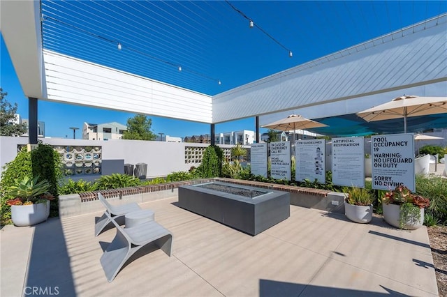 view of patio / terrace featuring an outdoor fire pit and fence