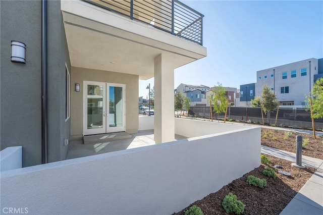 view of patio / terrace featuring a balcony, fence, and french doors