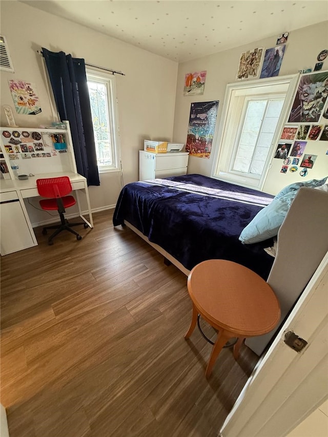 bedroom with wood finished floors and baseboards