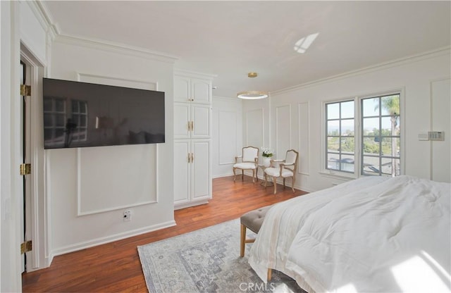 bedroom with dark wood-style floors, ornamental molding, and a decorative wall