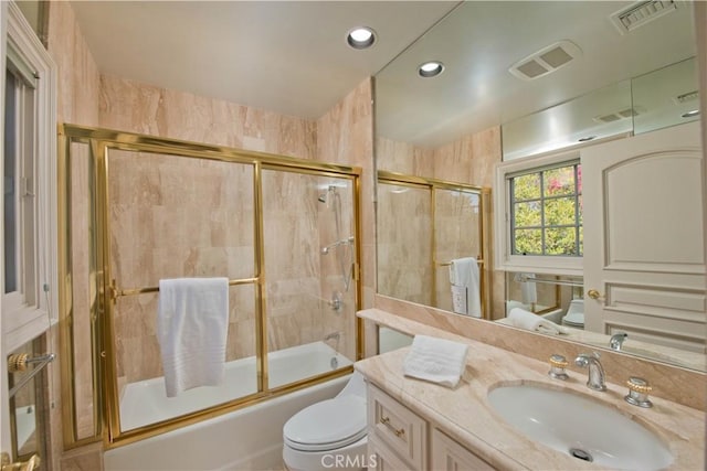 full bath with toilet, shower / bath combination with glass door, visible vents, and vanity